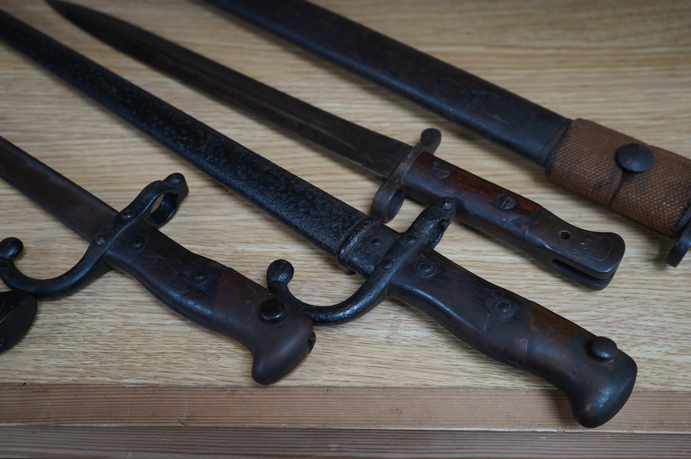 Six assorted bayonets; a 1907 pattern in its scabbard, a 1903 Wilkinson bayonet (no scabbard), two Gras bayonets (one in scabbard), a German Mauser bayonet, and a Remington First World War bayonet. Condition - poor to fa